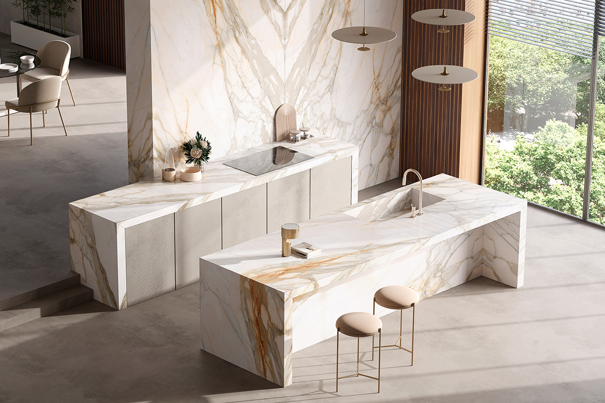 Cucina moderna con rivestimento in grandi lastre di grès porcellanato Optimum Borghini, effetto marmo bianco con venature dorate, isola centrale e backsplash in bookmatch, dallo stile elegante e scenografico.