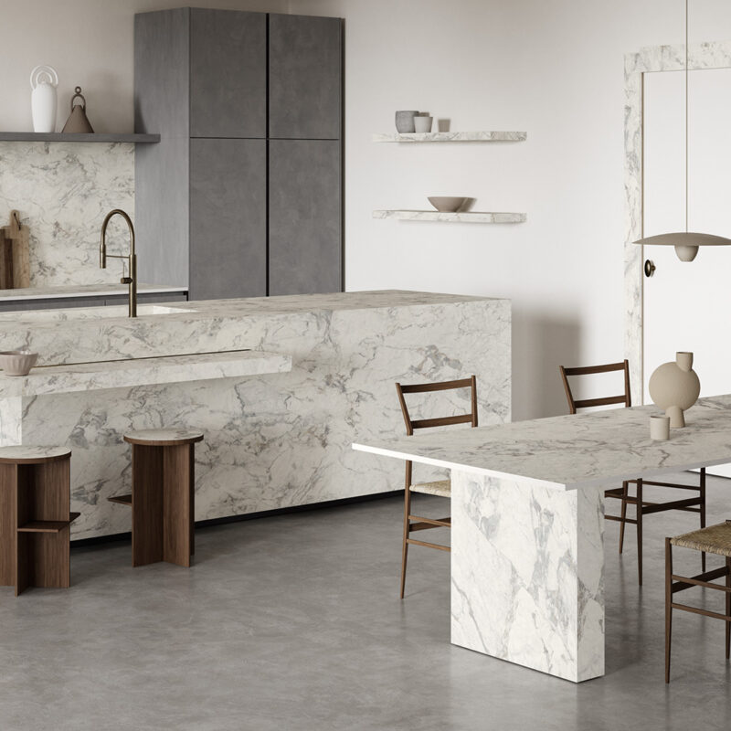 Cucina moderna con isola e pareti in grès effetto marmo bianco Calacatta Matarazzo Optimum, con venature delicate e finitura soft touch. Design elegante, luminoso e di grande formato.