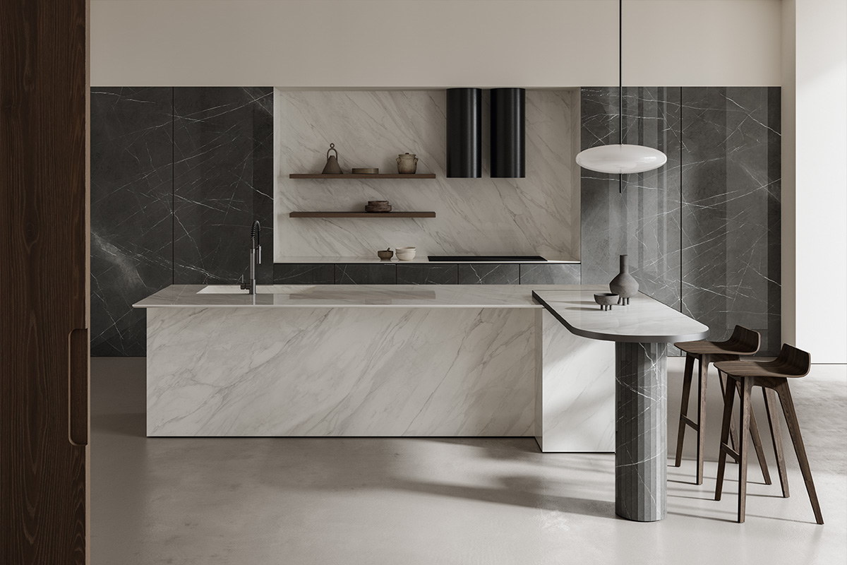 Cucina con isola e tavolo integrato in grès effetto marmo bianco Optimum Calacatta Supreme, pareti coordinate con venature decise e arredi moderni in materiali naturali.